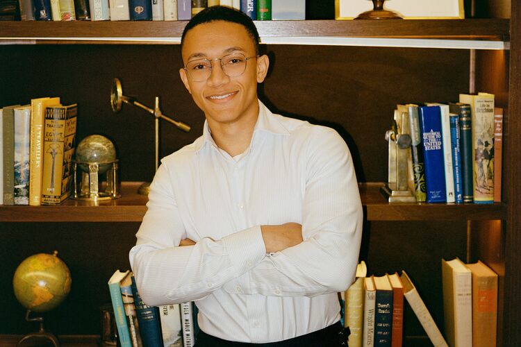 Portrait of Cosimo Fabrizio, standing in front of a bookshelf with his arms folded