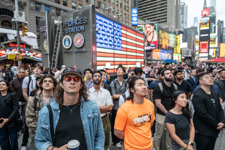Onlookers watch as Elon Musk, founder of SpaceX, appears on screen in Times Square during the company's initial public offering (IPO)