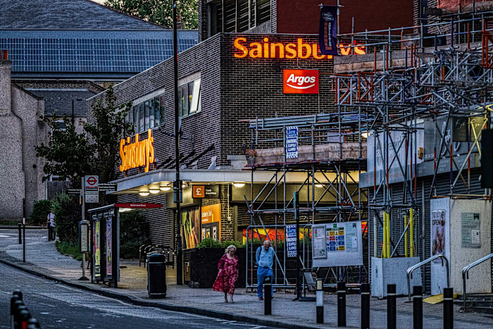 People walk past a Sainsbury's supermarket in London