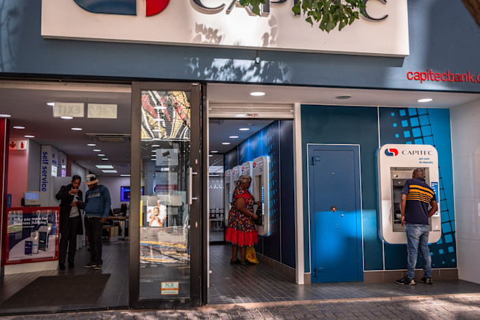 Customers use ATMs and interact inside a Capitec bank branch at Jewel City in Johannesburg.