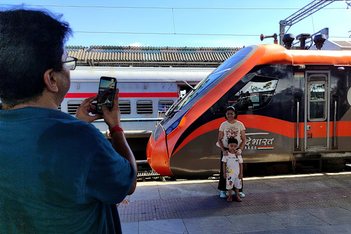 People take photos with the Vande Bharat Express at New Jalpaiguri station in West Bengal, India