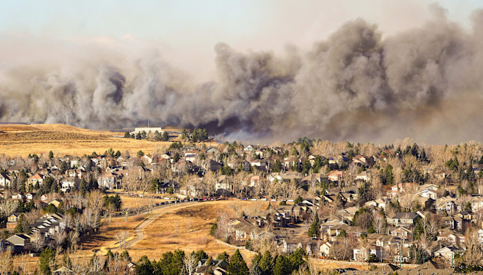 Thick smoke rises behind residential neighbourhoods in Superior, Colorado, as the Marshall Fire spreads across dry grasslands.