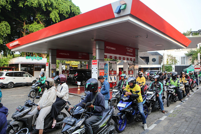 Long lines of people on motorbikes and some cars wait to refuel at a Pertamina gas station in Jakarta.