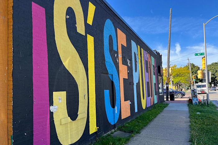 Large mural with colorful letters spelling “Sí se puede” on the side of a building in Milwaukee’s Latino neighborhood.