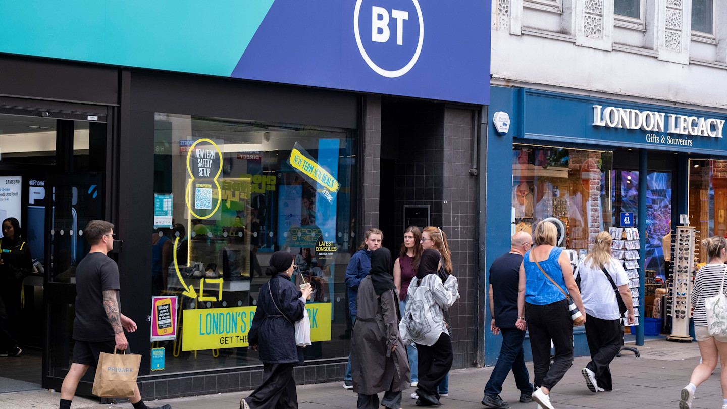 BT shop front on Oxford Street with several people walking past and a neighbouring souvenir shop, London Legacy, visible.
