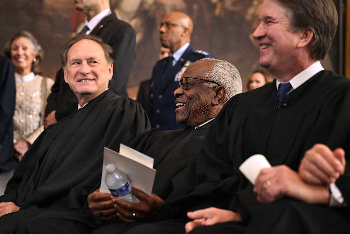 Samuel Alito, Clarence Thomas and Brett Kavanaugh share a laugh in judicial robes during the inauguration ceremonies.