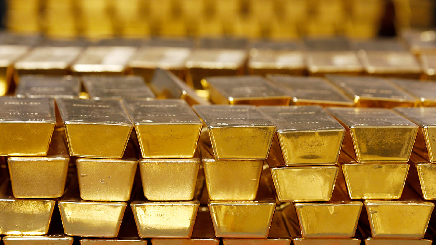 Stacks of gold bars arranged in rows inside a vault at the United States Mint.
