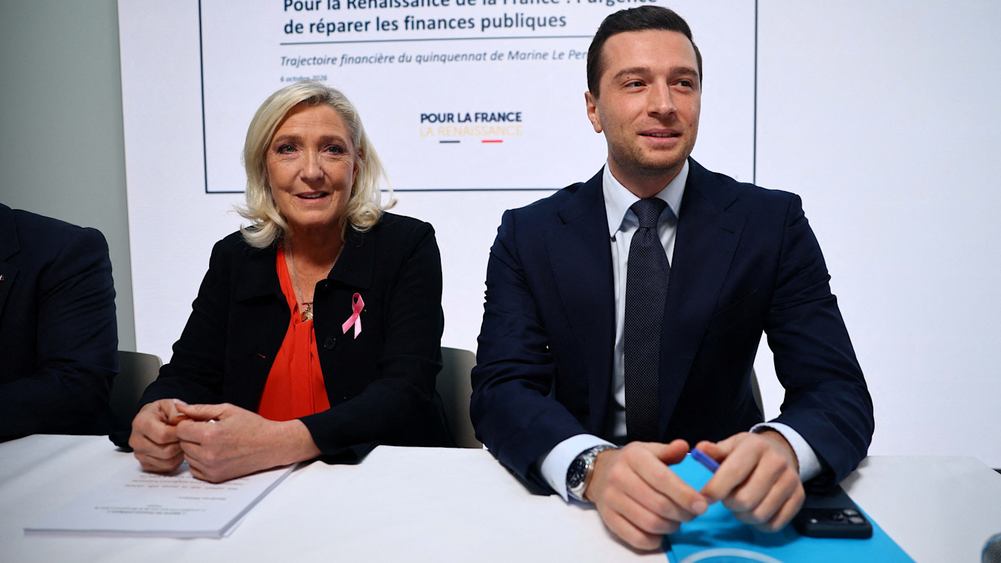 Marine Le Pen and Jordan Bardella sit at a table with budget documents.