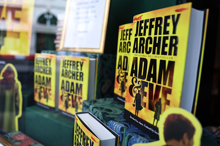 Several copies of Jeffrey Archer’s final book, ‘Adam & Eve’, are prominently displayed in a bookstore window.