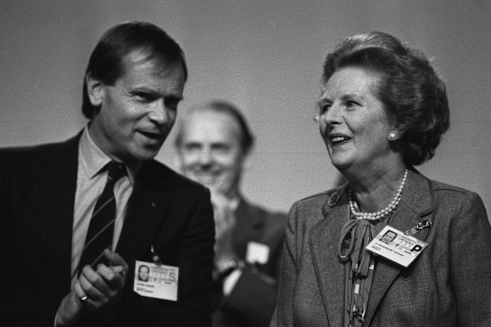Margaret Thatcher and Jeffrey Archer smiling and talking at the 1986 Conservative Party conference.