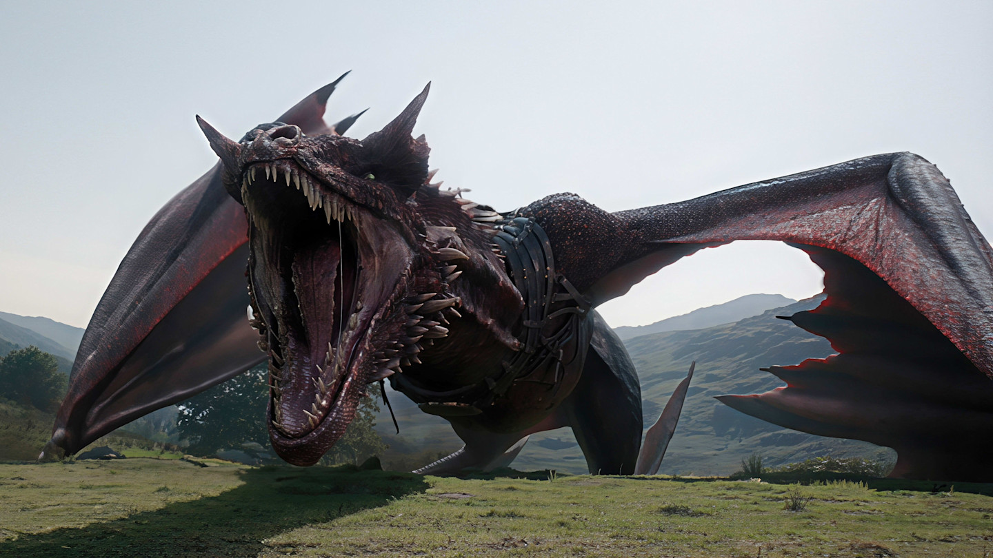 A dragon with its mouth open wide, showing sharp teeth, stands on a grassy landscape with mountains in the background.