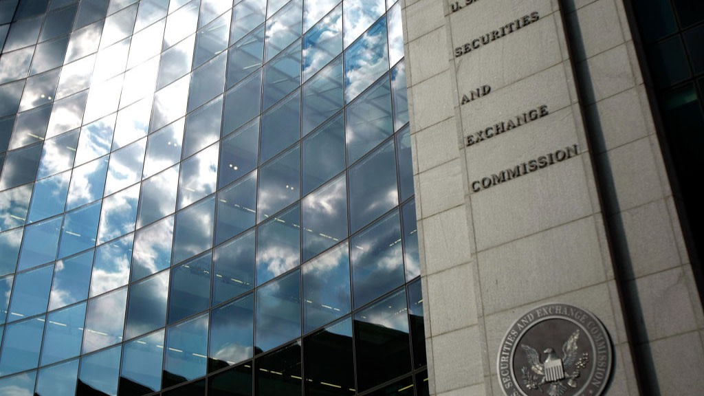 The US Securities and Exchange Commission seal on the exterior of a building with reflective glass windows.