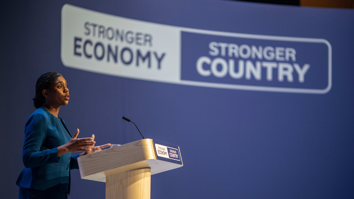 Kemi Badenoch speaks at a podium in front of a backdrop reading "Stronger Economy, Stronger Country" at the Conservative Party conference.
