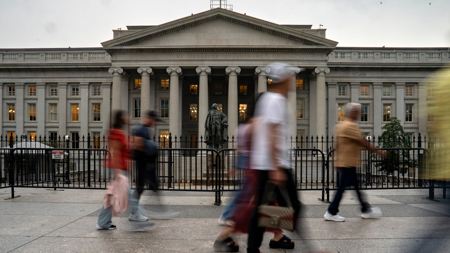 The US Treasury building with blurred pedestrians walking past in the foreground.