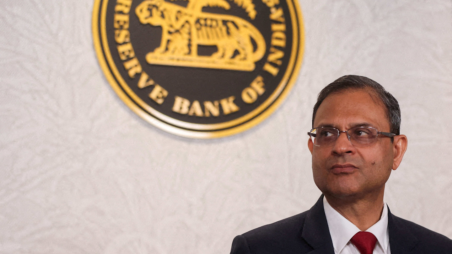 Sanjay Malhotra stands in front of the Reserve Bank of India emblem at a press conference
