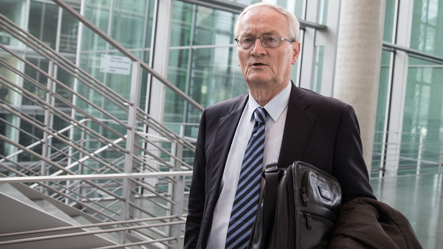 August Hanning carries a briefcase and coat as he arrives at the Bundestag in Berlin.
