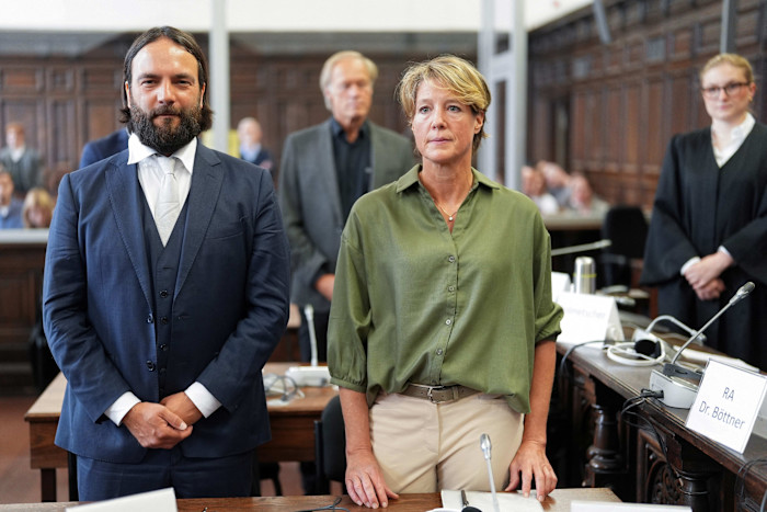 Christina Block stands next to her lawyer Ingo Bott in a courtroom, with Gerhard Delling standing behind them.