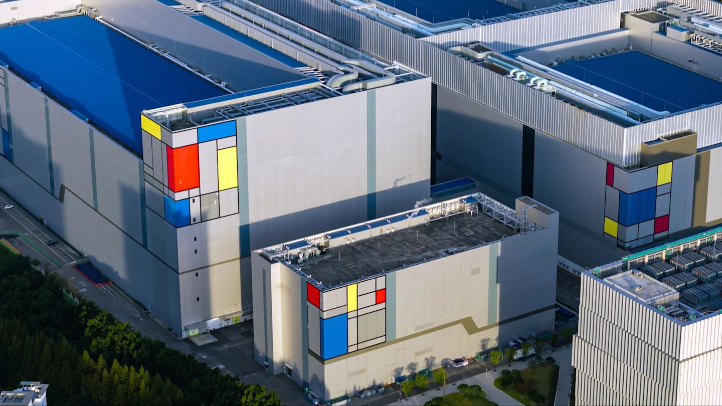 Aerial view of the chipmaking plant featuring large, modern buildings with geometric colour block patterns on the exterior walls.