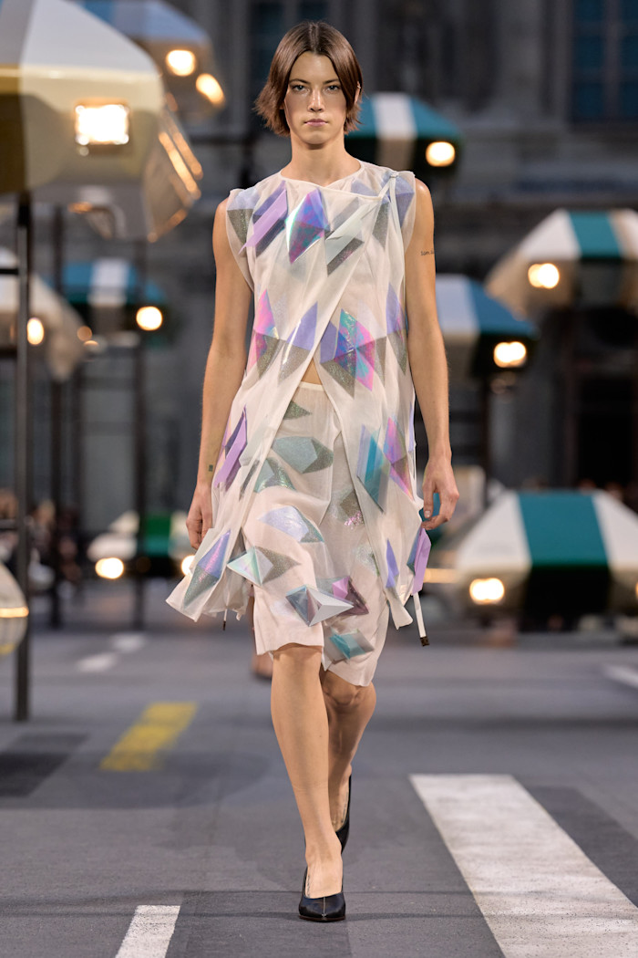 A model wears a sleeveless dress made of sheer material with blocks of colour.