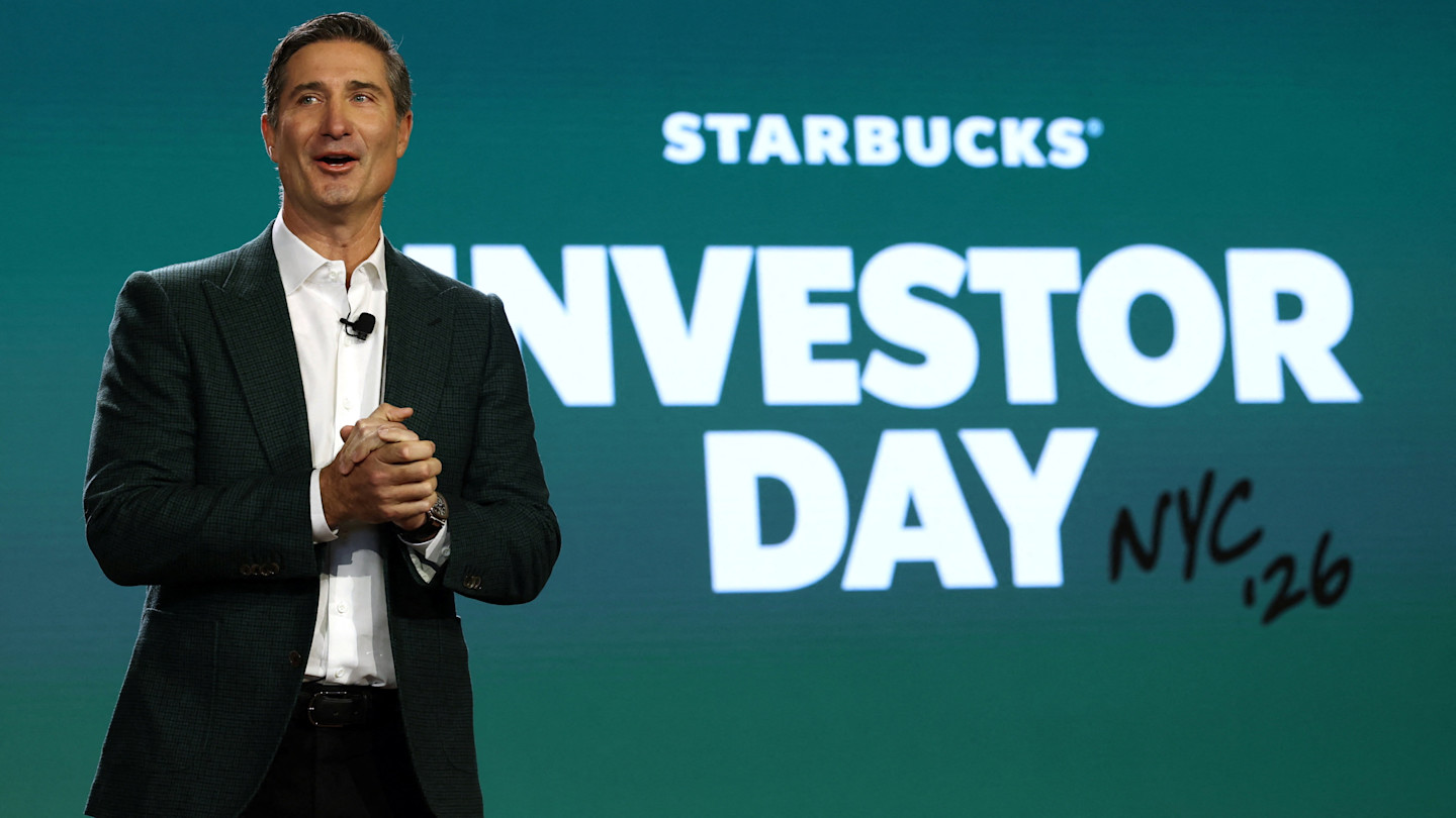 Brian Niccol speaks on stage in front of a large "Starbucks Investor Day NYC '26" sign.