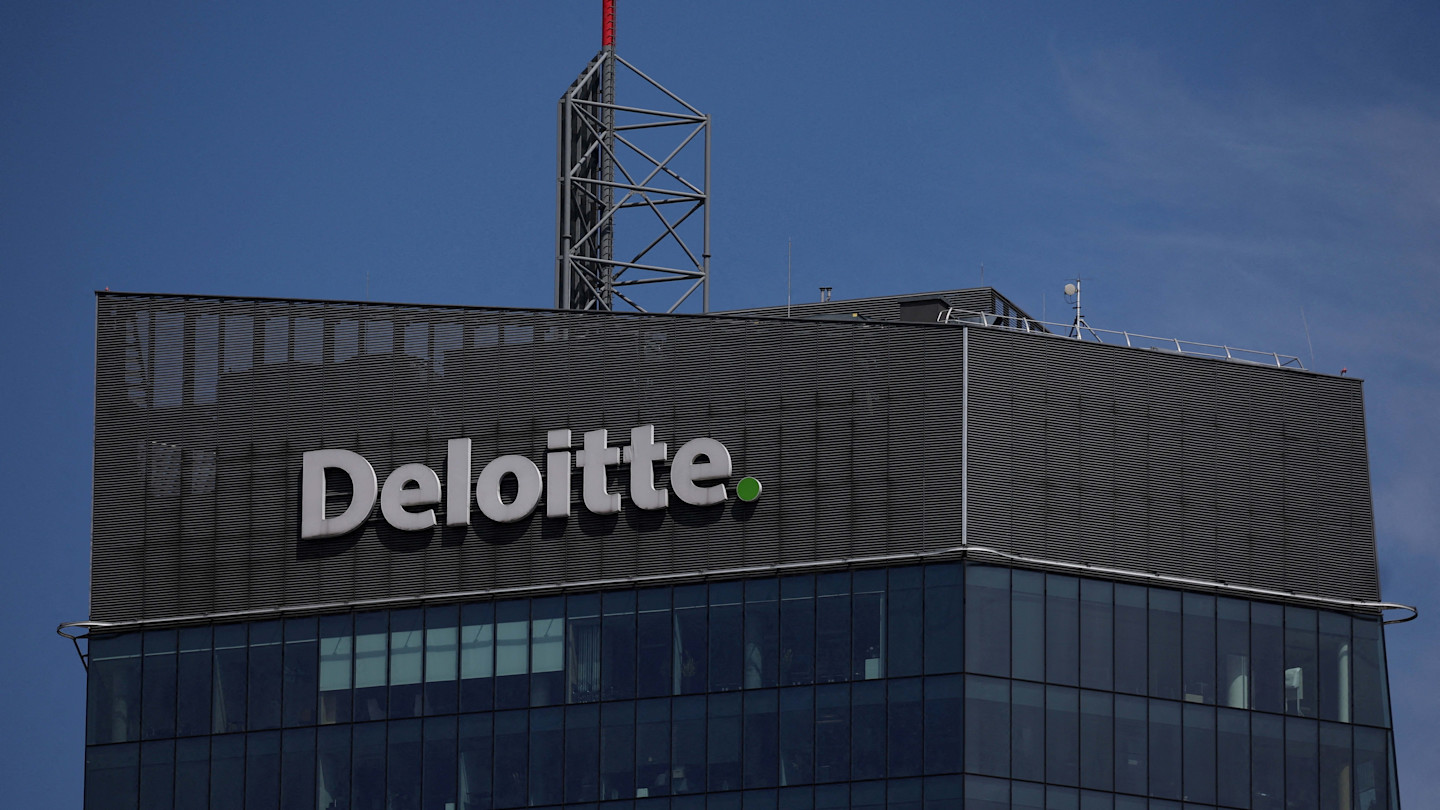 Deloitte company logo displayed on the upper facade of a modern office building in Warsaw.