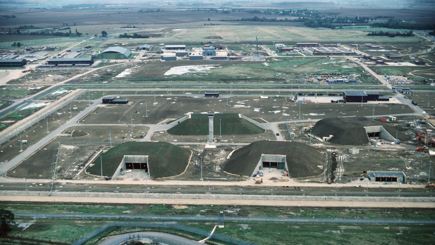 Aerial view of missile storage bunkers and military buildings at RAF Molesworth, showing multiple earth-covered structures.