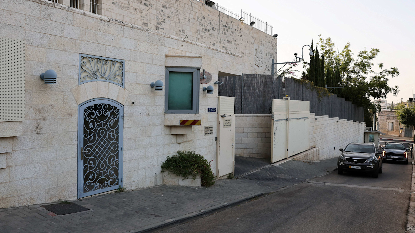 Two vehicles approach the entrance of the British consulate in East Jerusalem, with signage removed from the building.