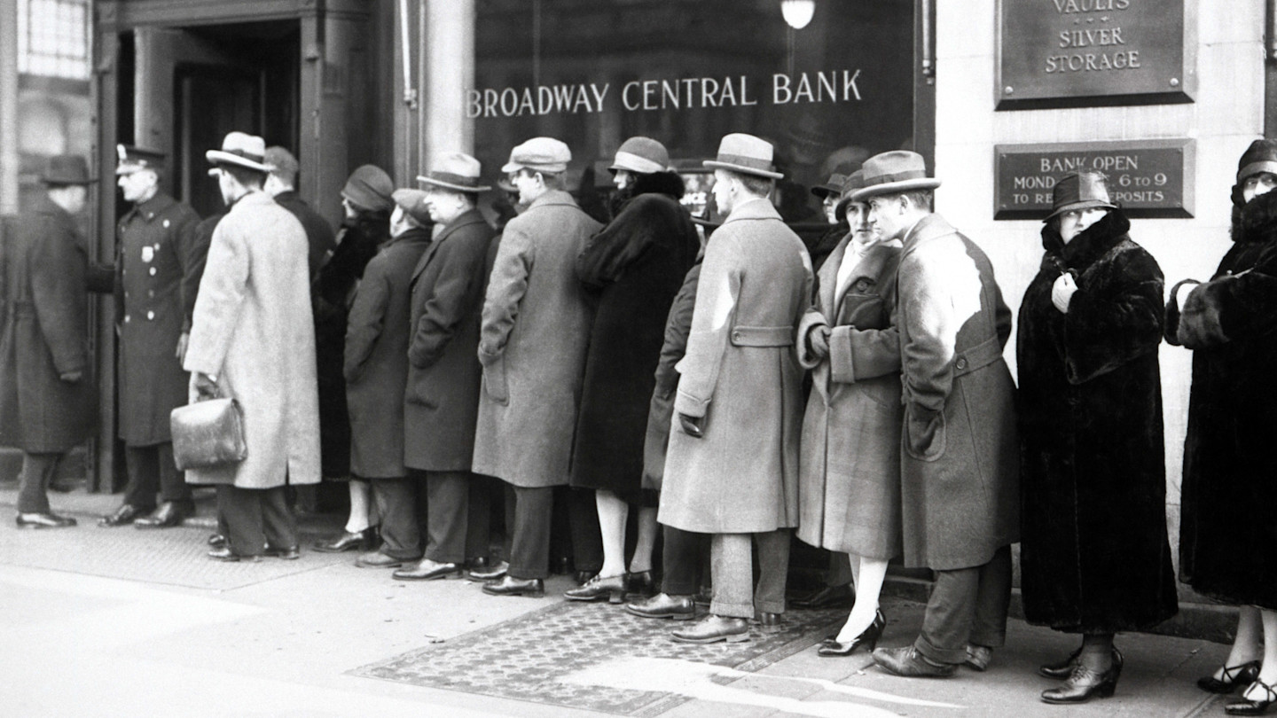 People in heavy coats and hats wait in a long line outside the Broadway Central Bank, likely during a bank run.