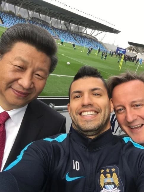 President Xi Jinping, Sergio Agüero, and Prime Minister David Cameron smile for a selfie at a football training ground.