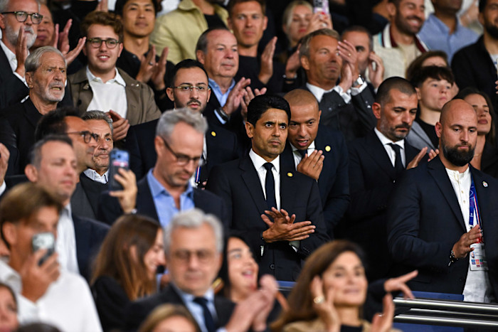 Nasser Al-Khelaifi and Nicolas Sarkozy in the stands among a crowd during the Champions League match at Parc des Princes.