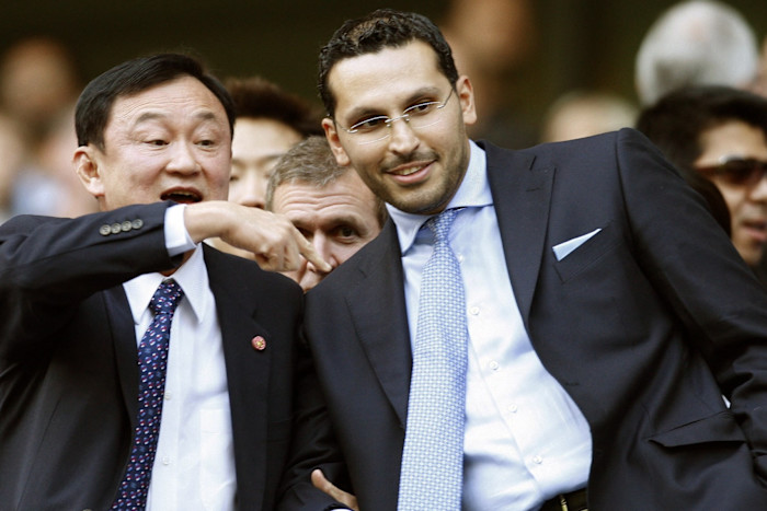 Thaksin Shinawatra gestures while standing next to Khaldoon Al Mubarak before a Manchester City football match.