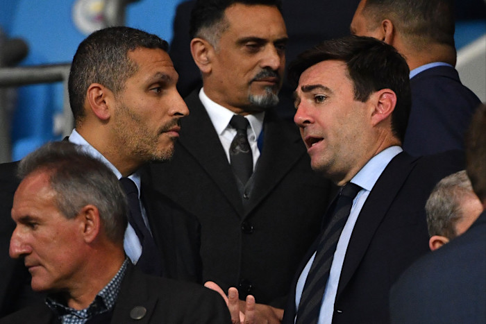 Khaldoon al-Mubarak talks with Andy Burnham in the stands during the Vincent Kompany testimonial football match.
