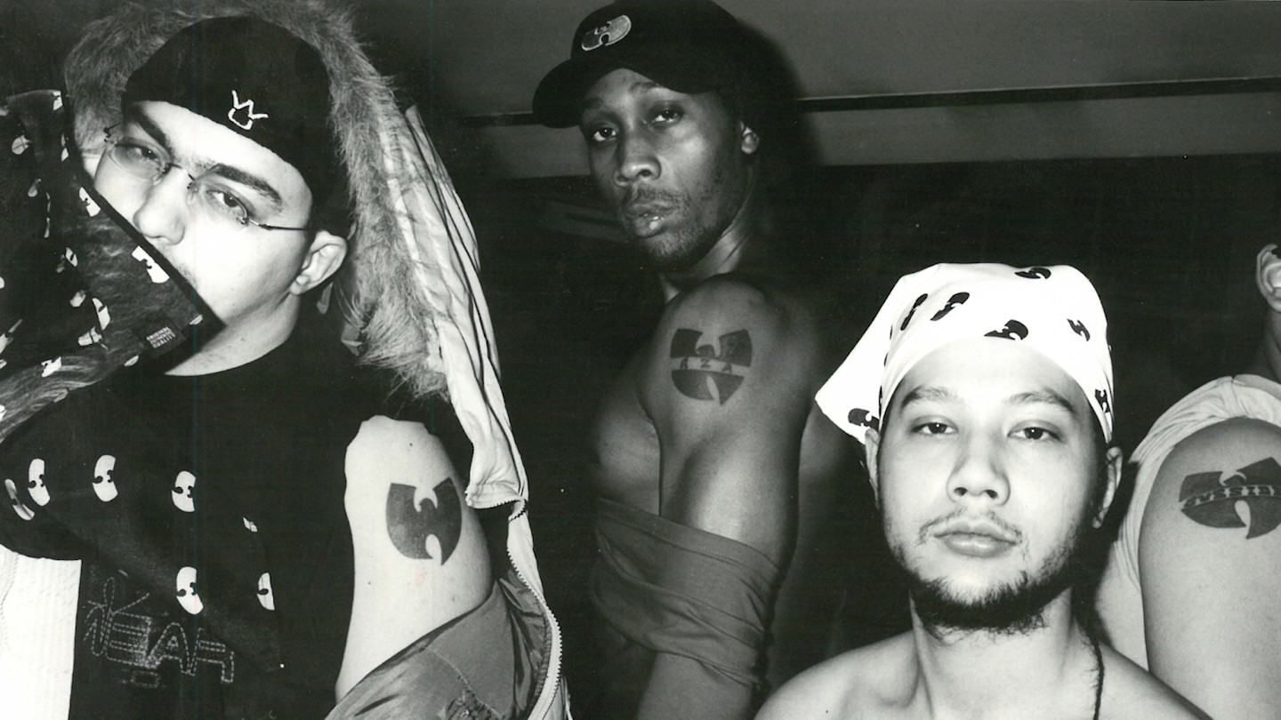 Tarik Azzougarh, The RZA, and Jeremy Waterloo pose together, each showing a Wu-Tang Clan tattoo on their upper arm.