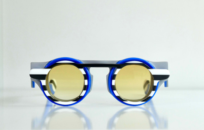 A pair of glasses with round, blue, black and white frames.