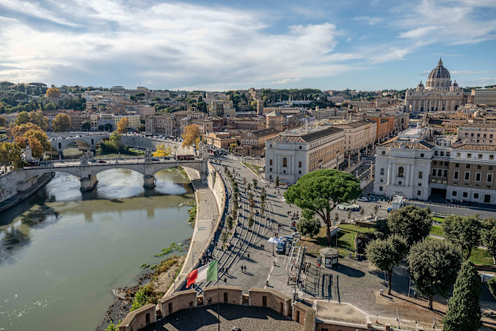 Aerial view of Ponte Vittorio Emanuele II over the Tiber River, Piazza Pia, Via della Conciliazione, and St. Peter's Basilica in Rome.