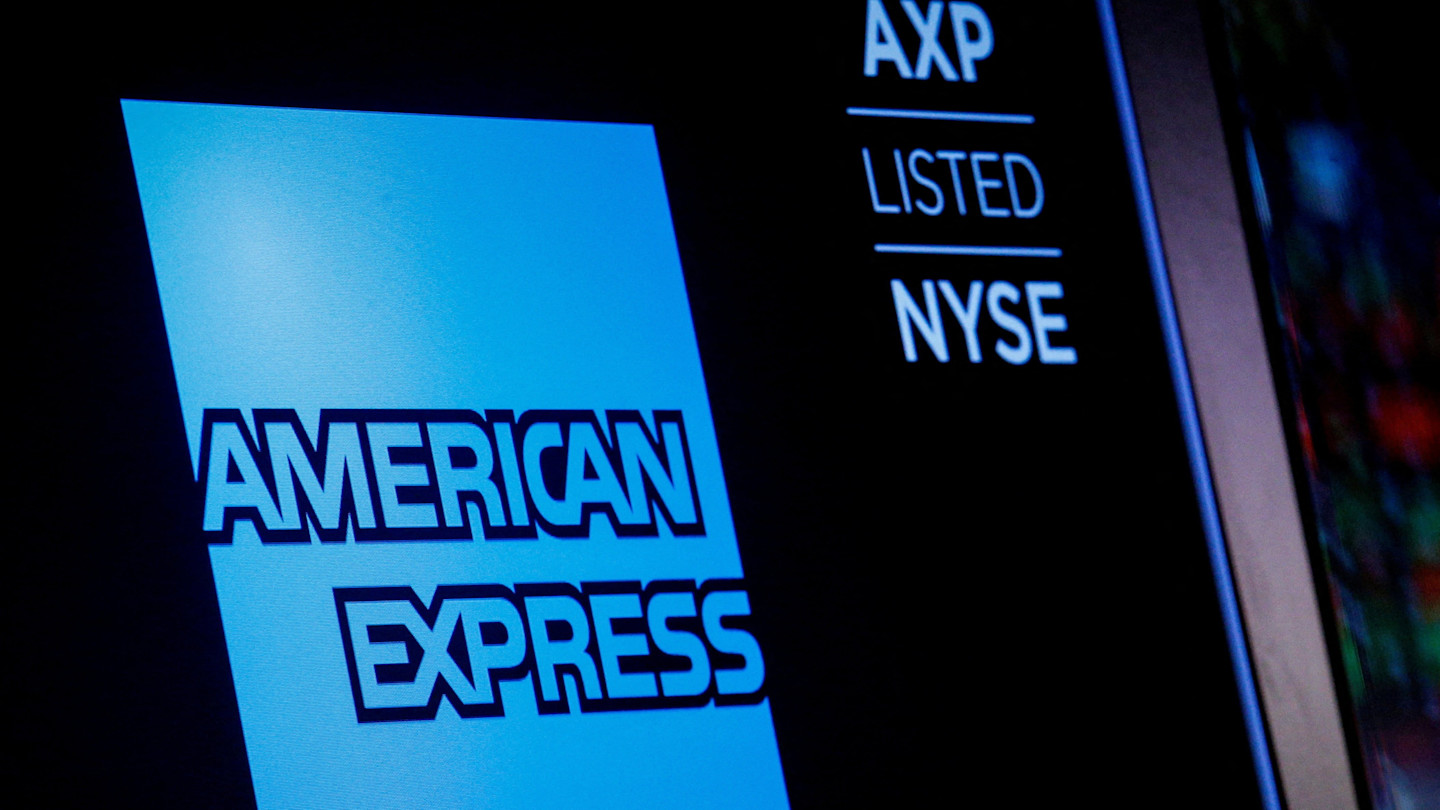 American Express logo displayed on a screen alongside the ticker symbol AXP and the words "Listed NYSE."