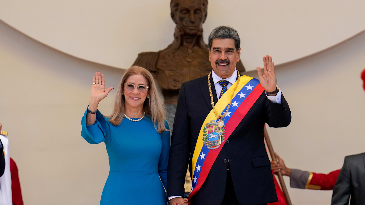 Nicolás Maduro and Cilia Flores wave and hold hands after Maduro’s swearing-in ceremony in 2025