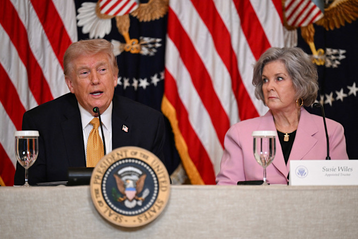 Donald Trump speaks at a table next to Susie Wiles, who is looking at him, during a White House lunch event.