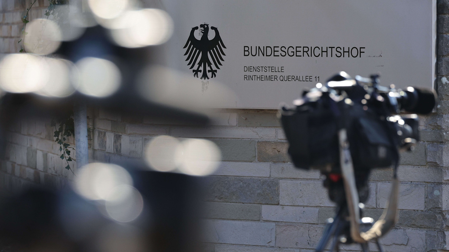 Television cameras set up outside the Federal Court of Justice in Karlsruhe, with the court’s sign and emblem visible in the background.