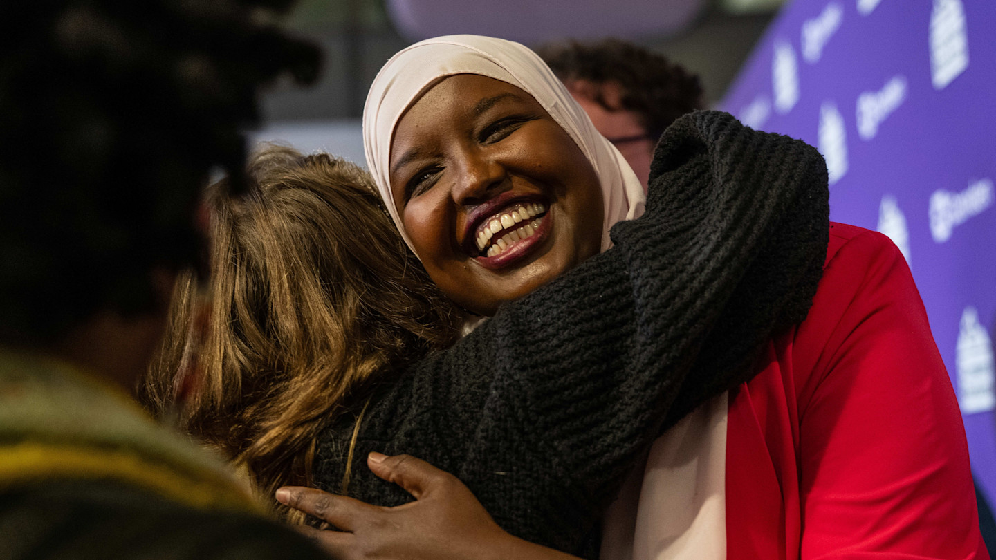 Sagal Abdi-Wali smiling and being hugged by a supporter