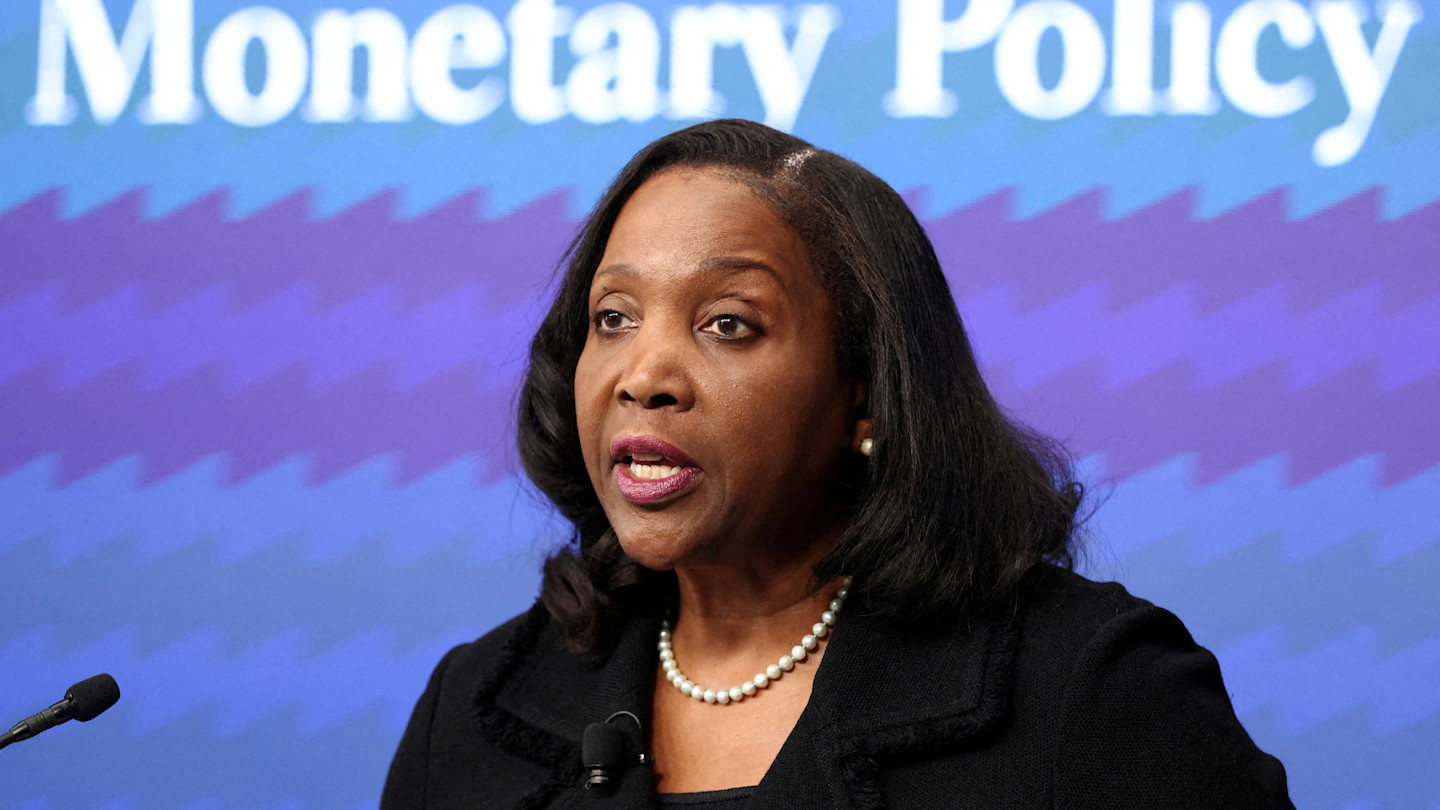 Lisa Cook speaks at a podium in front of a screen displaying the words Monetary Policy