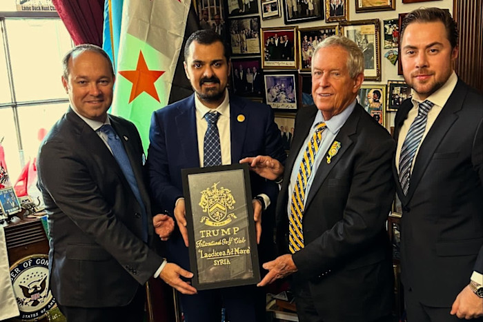 Mohamad Al Khayyat, Congress member Joe Wilson and Congress member Marlin Stutzman stand with another man, holding a framed foundation stone for the Trump International Golf Club project.