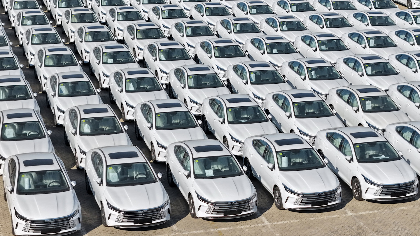 Rows of white BYD plug-in hybrid cars are parked closely together in Yantai in eastern China’s Shandong province