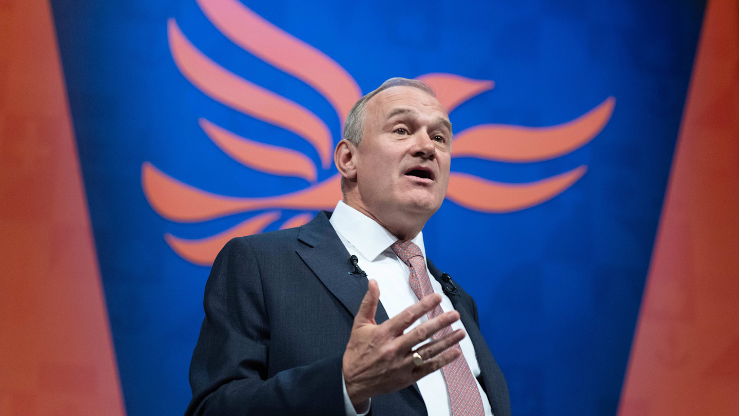 Ed Davey speaks on stage with the Liberal Democrat party logo behind him during the party conference.
