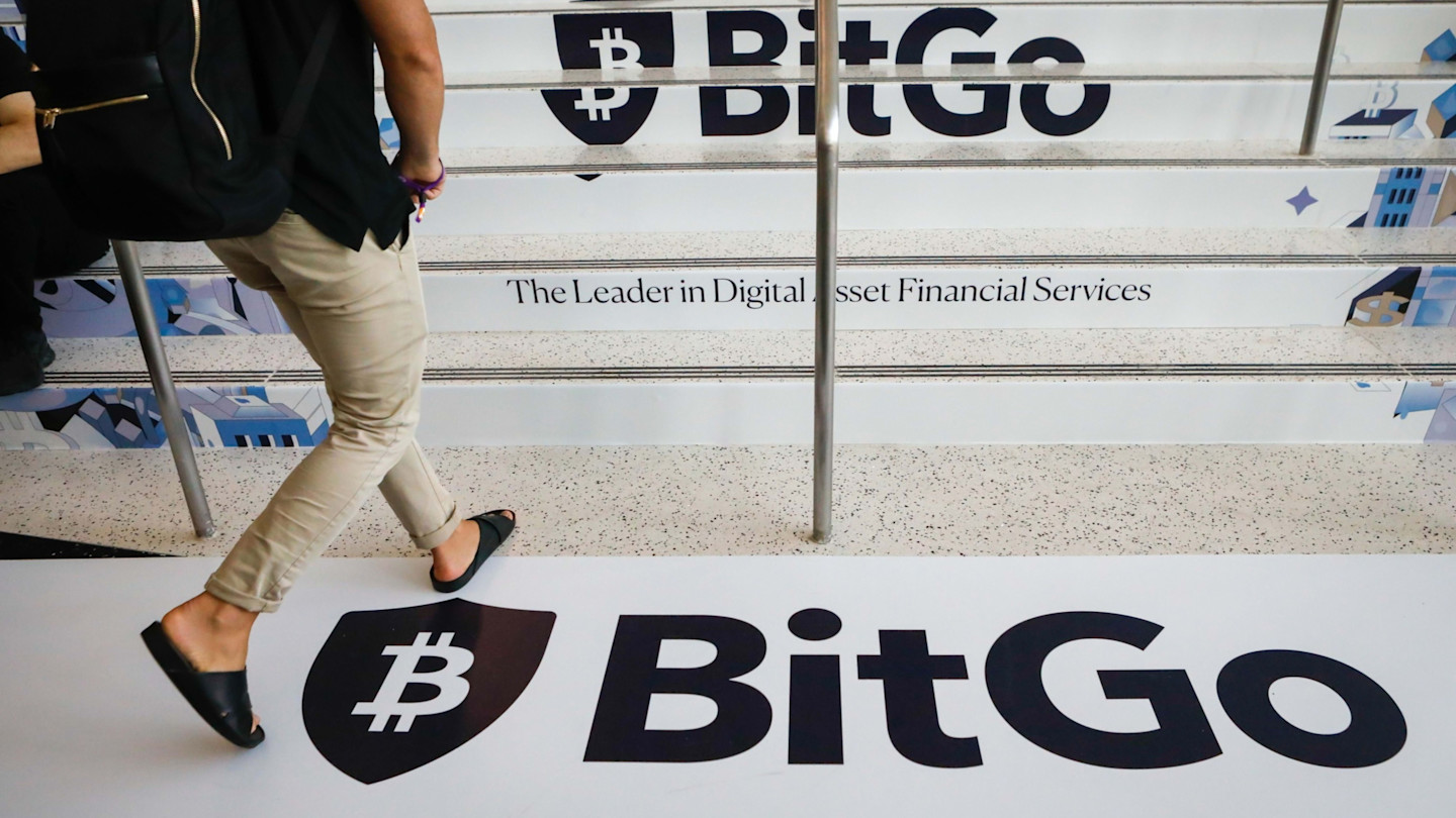 BitGo logo and slogan displayed on stairs and floor at a conference, with a person walking past.