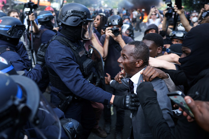 Saint-Denis Mayor Bally Bagayoko shouts as he stands between protesters and police officers during a student demonstration in Paris.