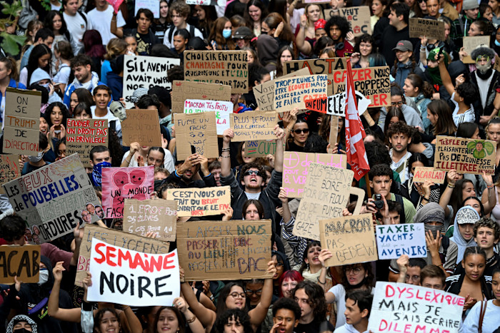 A large crowd of high-school students in Marseille holds handmade protest signs demanding better school conditions and criticizing authorities.