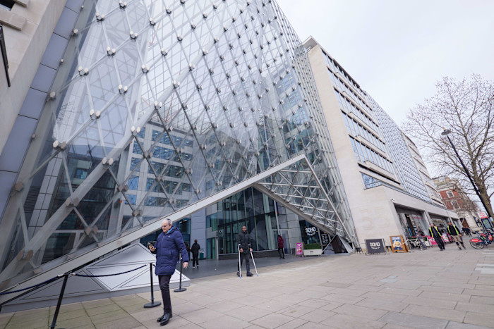 Striking glass and steel facade of 55 Baker Street in London, showing its geometric design and people walking by the entrance.