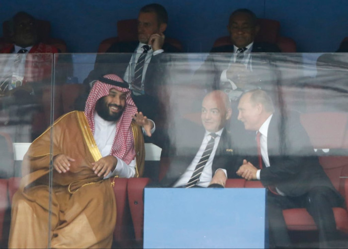 Saudi Arabia Crown Prince Mohammed bin Salman, Fifa President Gianni Infantino, and Russian President Vladimir Putin seated together watching a soccer match.