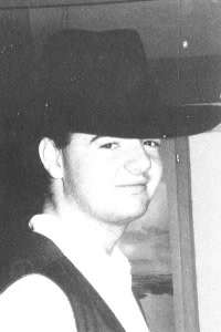 A young Gianni Infantino wearing a large brimmed hat and vest, smiling slightly at the camera in a black-and-white photo.
